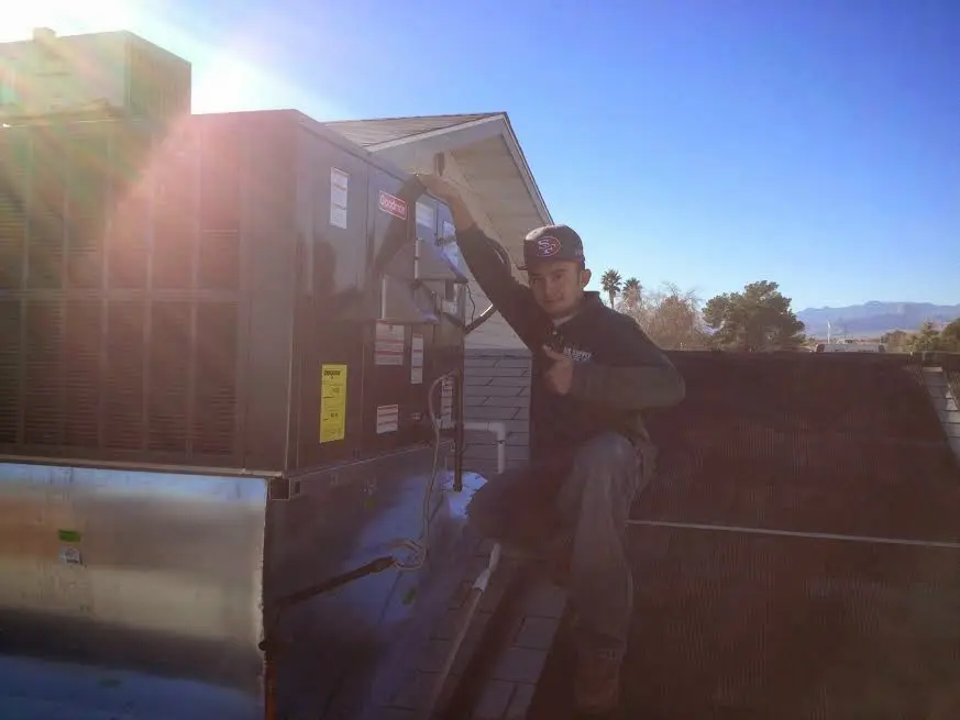 HVAC technician performing HVAC Inspection on a rooftop unit in Lacey
